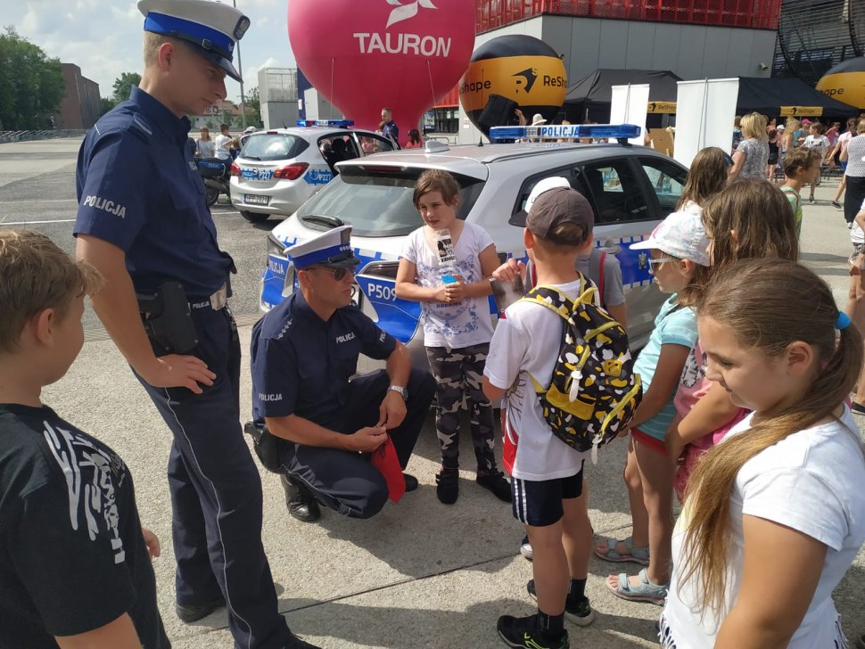 zdjęcie kolorowe: policjanci pod stadionem miejskim w Zabrzu rozmawiaja z dziećmi