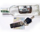 Kluczyki samochodowe i butelka alkoholu