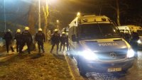 Policjanci stojący przy radiowozie i kibice drużyny Lechii Gdańska przy stadionie piłkarskim w Zabrzu