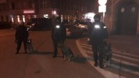 3 policjantów z psami służbowymi przed budynkiem poczty w centrum Zabrza
