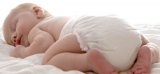 Zdjęcie kolorowe: śpiący niemowlak w pieluszce jednorazowej