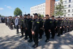 Zdjęcie kolorowe: nowo przyjęci policjanci na placu apelowym przed budynkiem oddziałów prewencji w Katowicach
