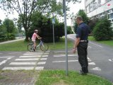 zdjęcie kolorowe: Policjant ocenia sposób jazdy na rowerze egzaminowanego ucznia