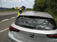 Zdjęcie kolorowe: policjant drogówki podczas kontroli pojazdu