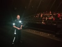 zdjęcie kolorowe: policjant w kinie stoji przed widownią