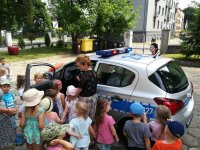 Zdjęcie kolorowe:  grupa dzieci przy radiowozie policyjnym