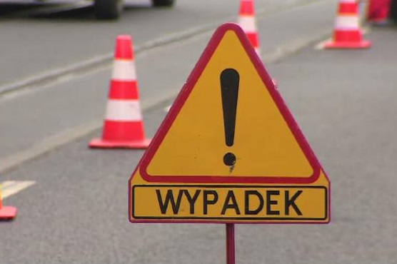 Zdjęcie kolorowe: żółty znak drogowy z napisem wypadek