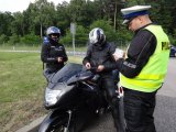 zdjęcie kolorowe: policjant wykonuje czynności z motocyklistą