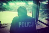 Zdjęcie kolorowe: policjant obserwuje mecz z centrum dowodzenia
