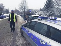 Policjant na miejscu kolizji drogowej w zimowych warunkach atmosferycznych